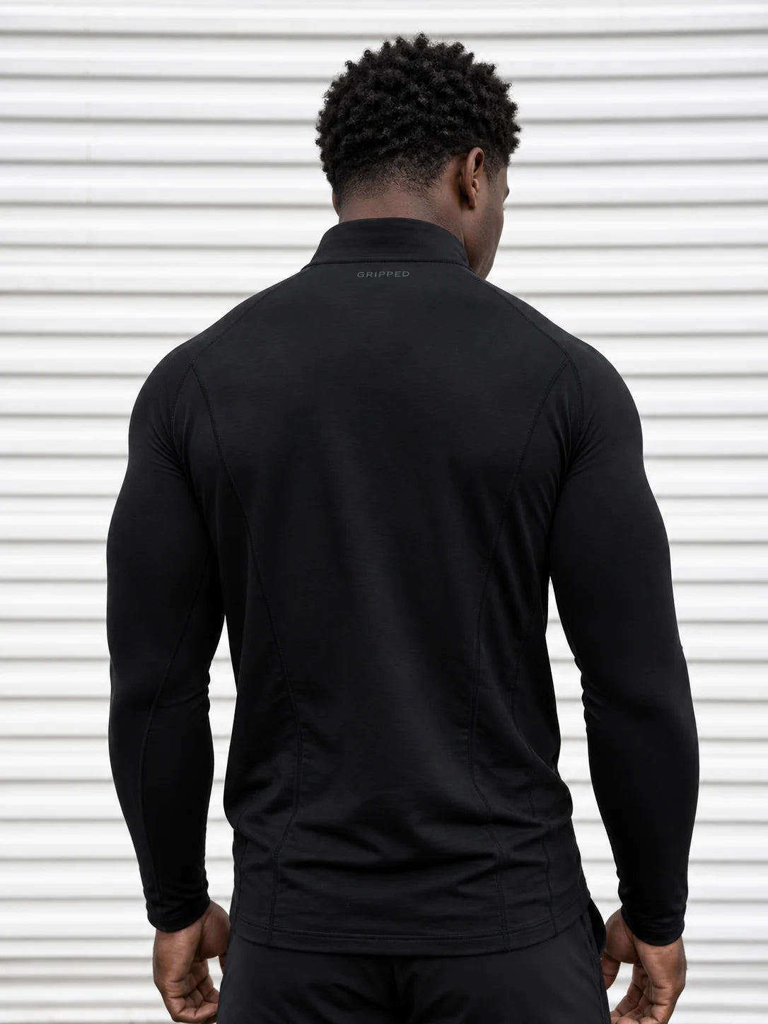 Quarter Zip negro — silueta entallada de espalda