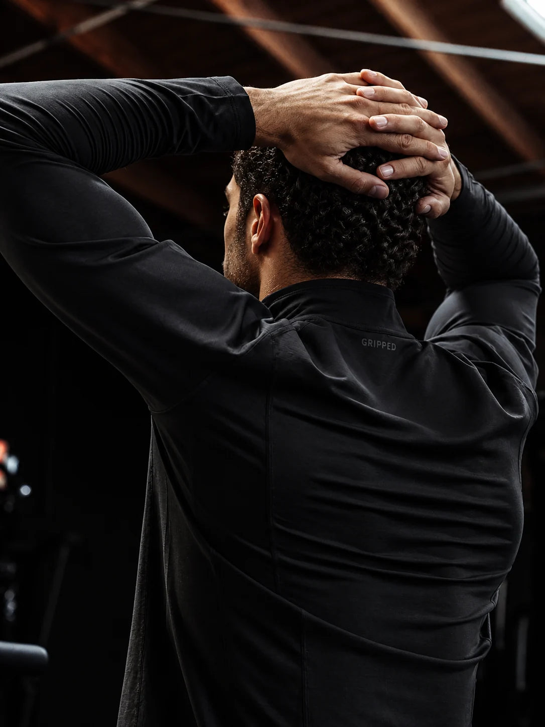 Quarter Zip negro — logo Gripped discreto en la espalda